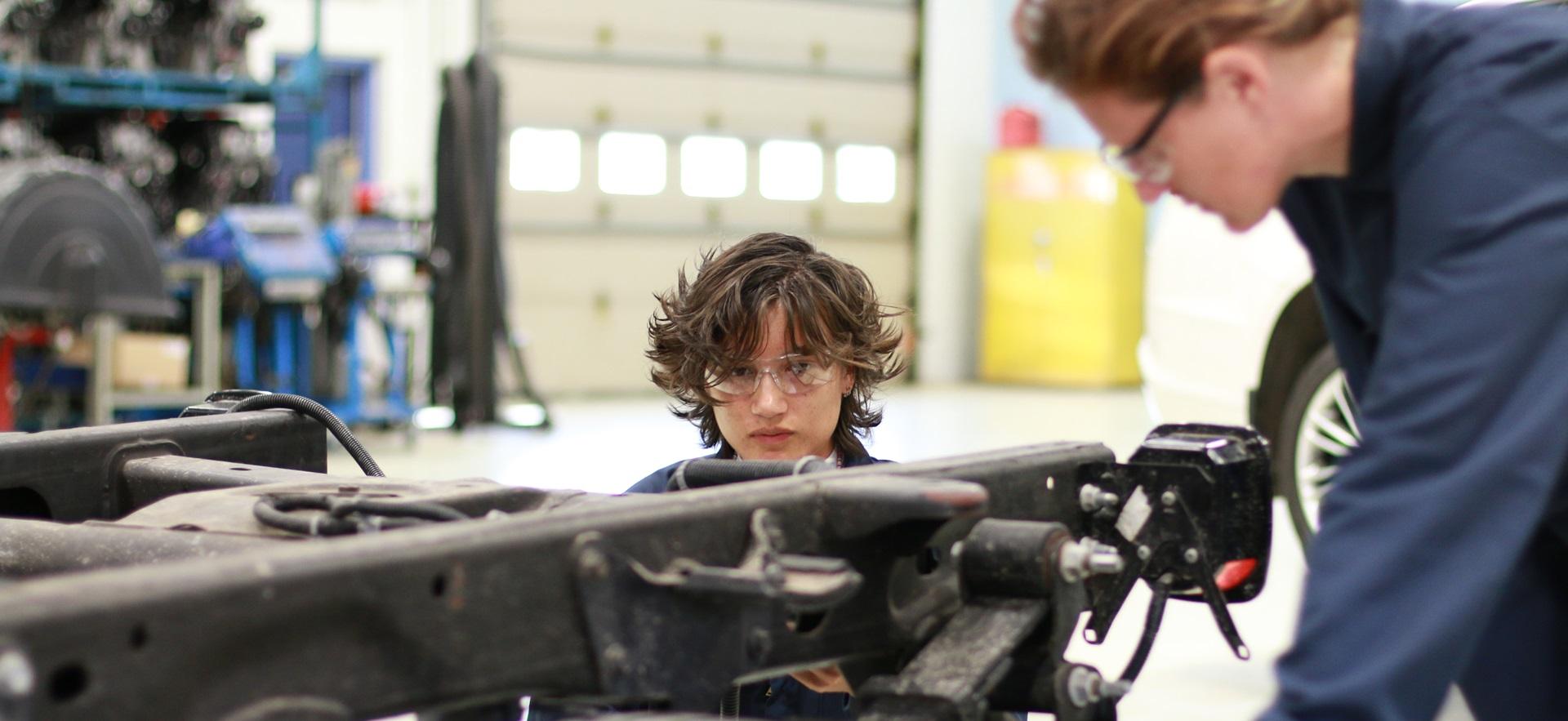 Motive Power students looking at vehicle frame