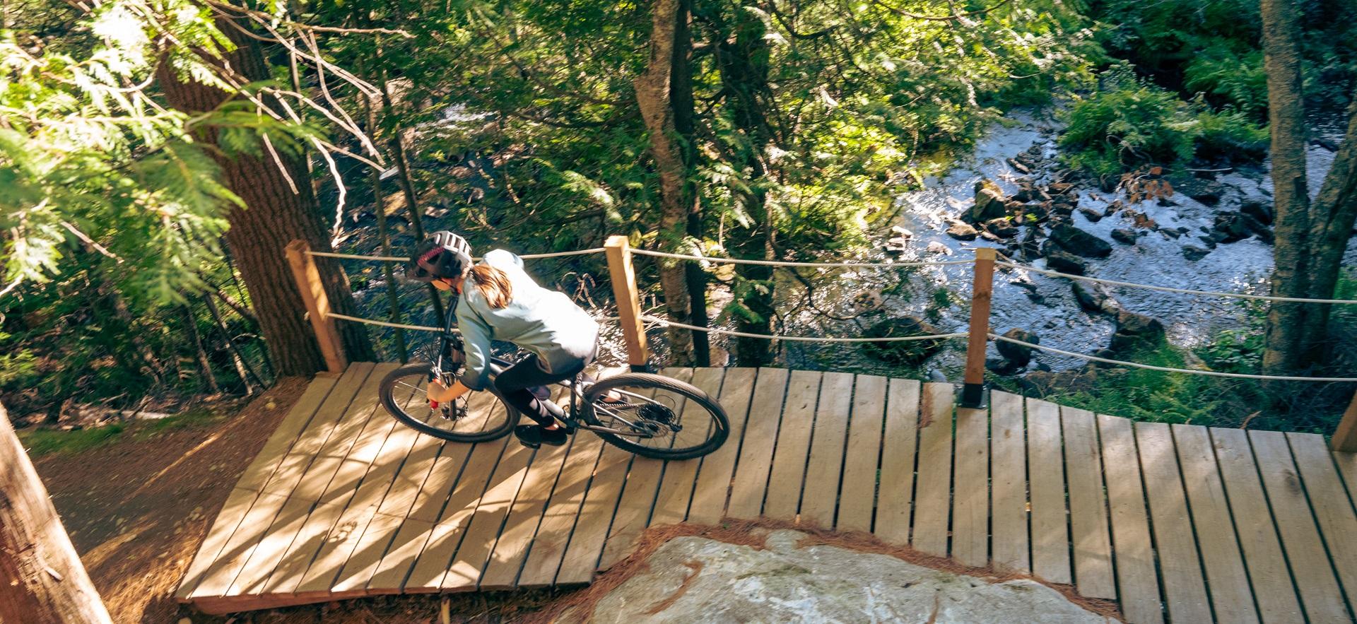 Woman on bike over bridge path at Hiawatha by waterfalls show aerial view