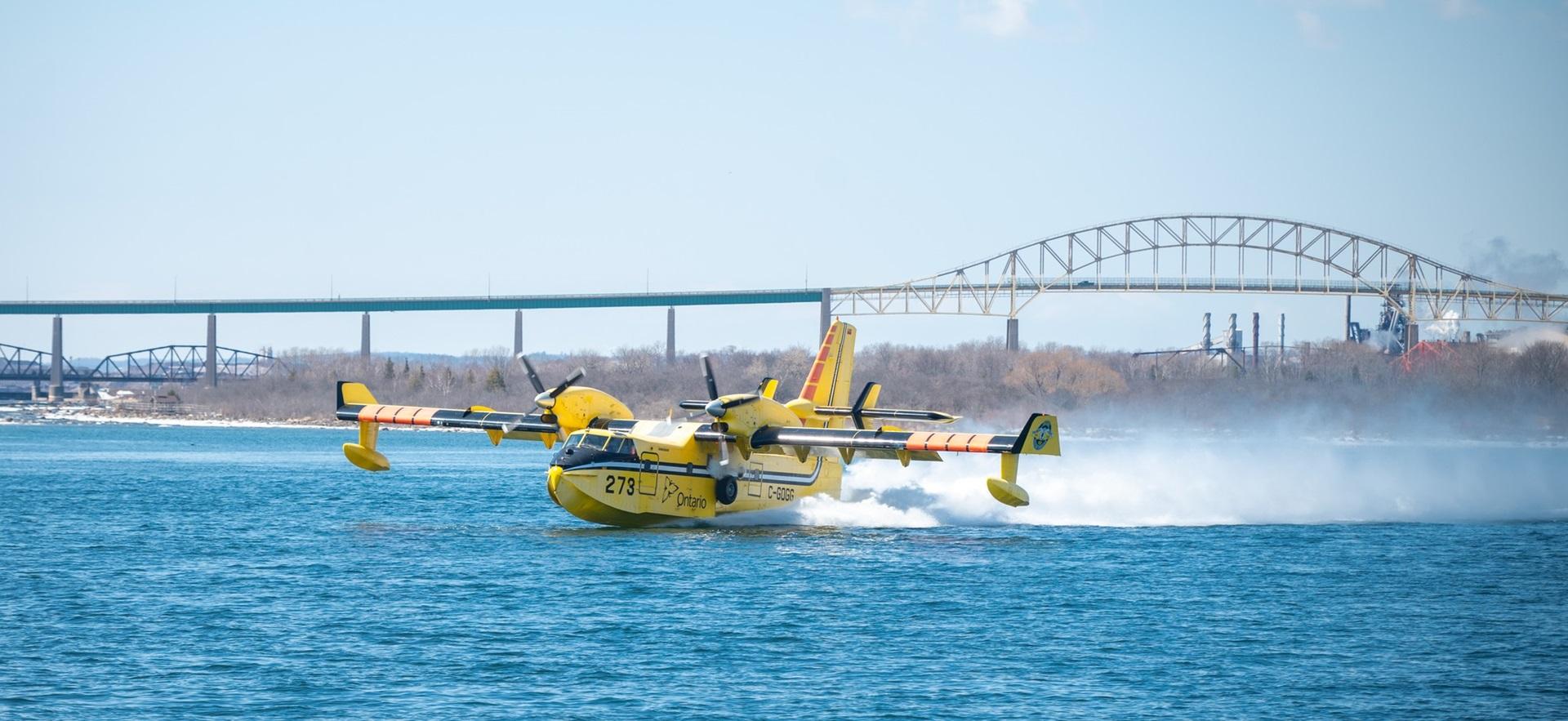 Bushplane landing on water with International Bridge in background