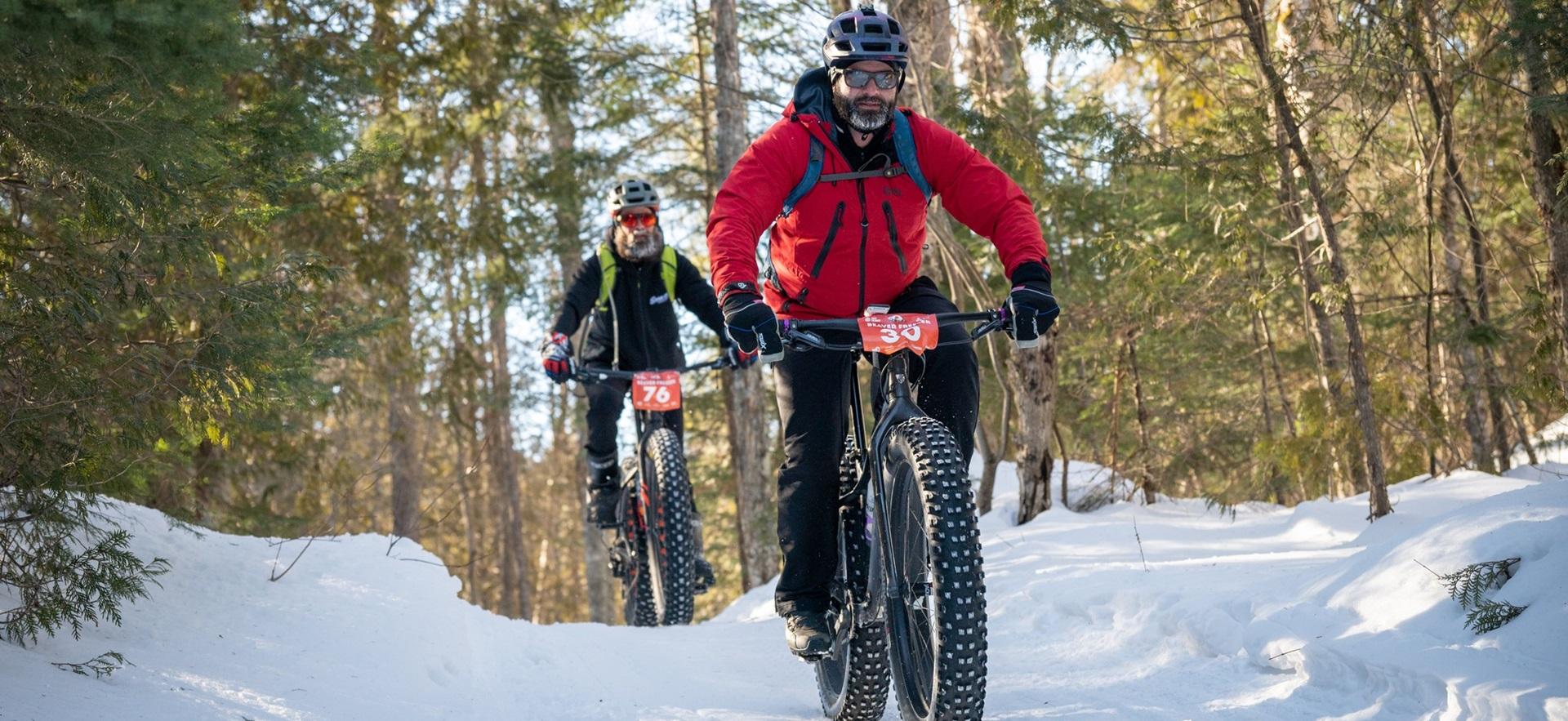 Two men fat biking on a snowy trail