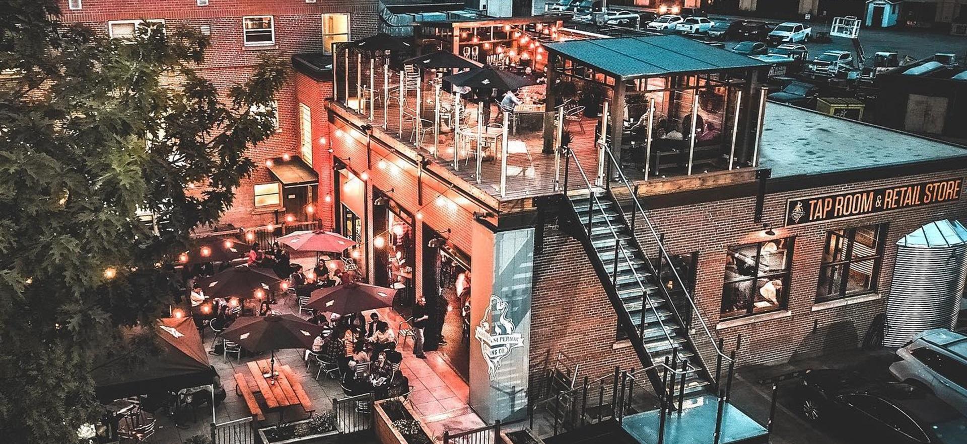 Aerial view of Taproom lit up at night in the summer