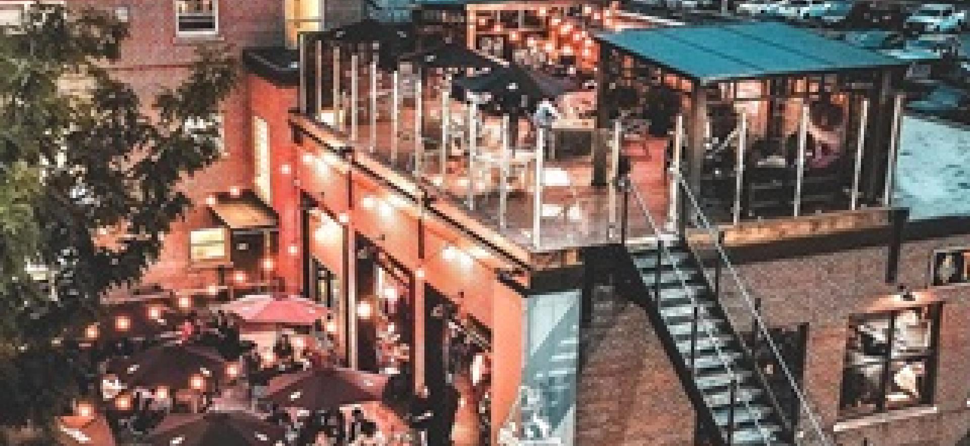 Aerial view of Taproom lit up at night in the summer