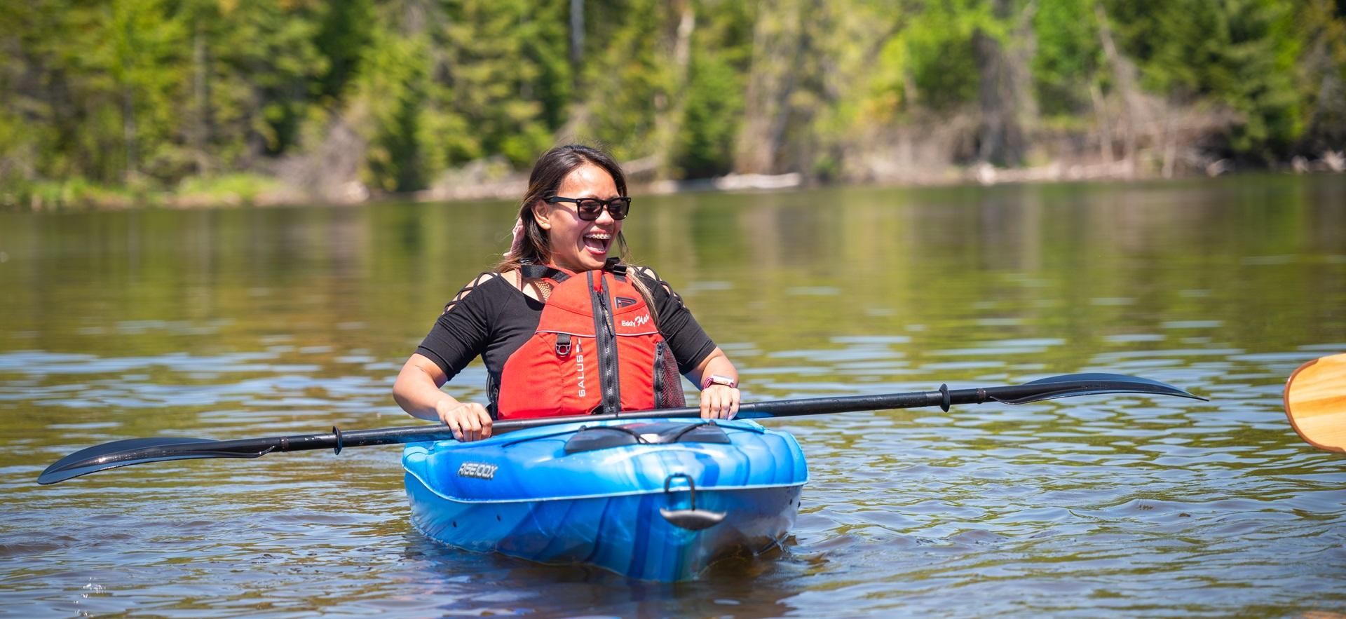 Woman laughing in kayak on the water