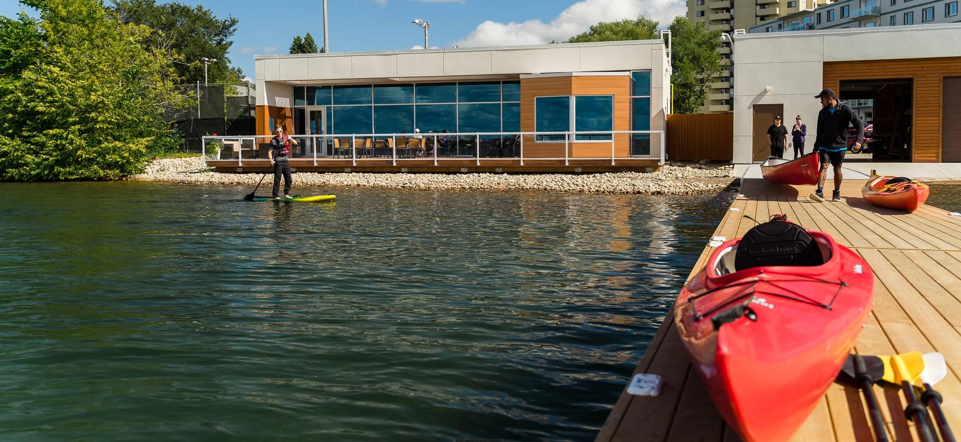 Waterfront Adventure Centre showing patio, dock, boat and paddler on water