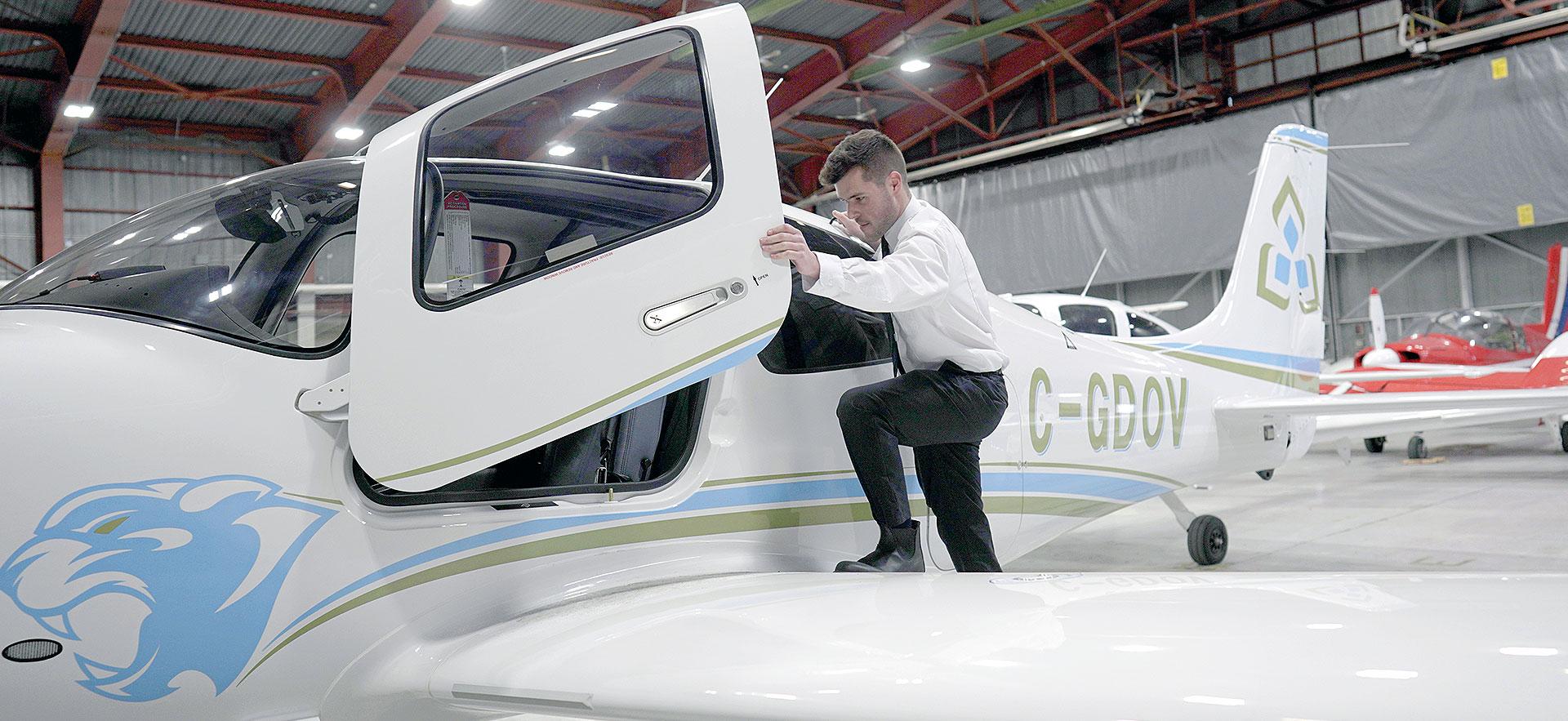 Student pilot climbing into plane