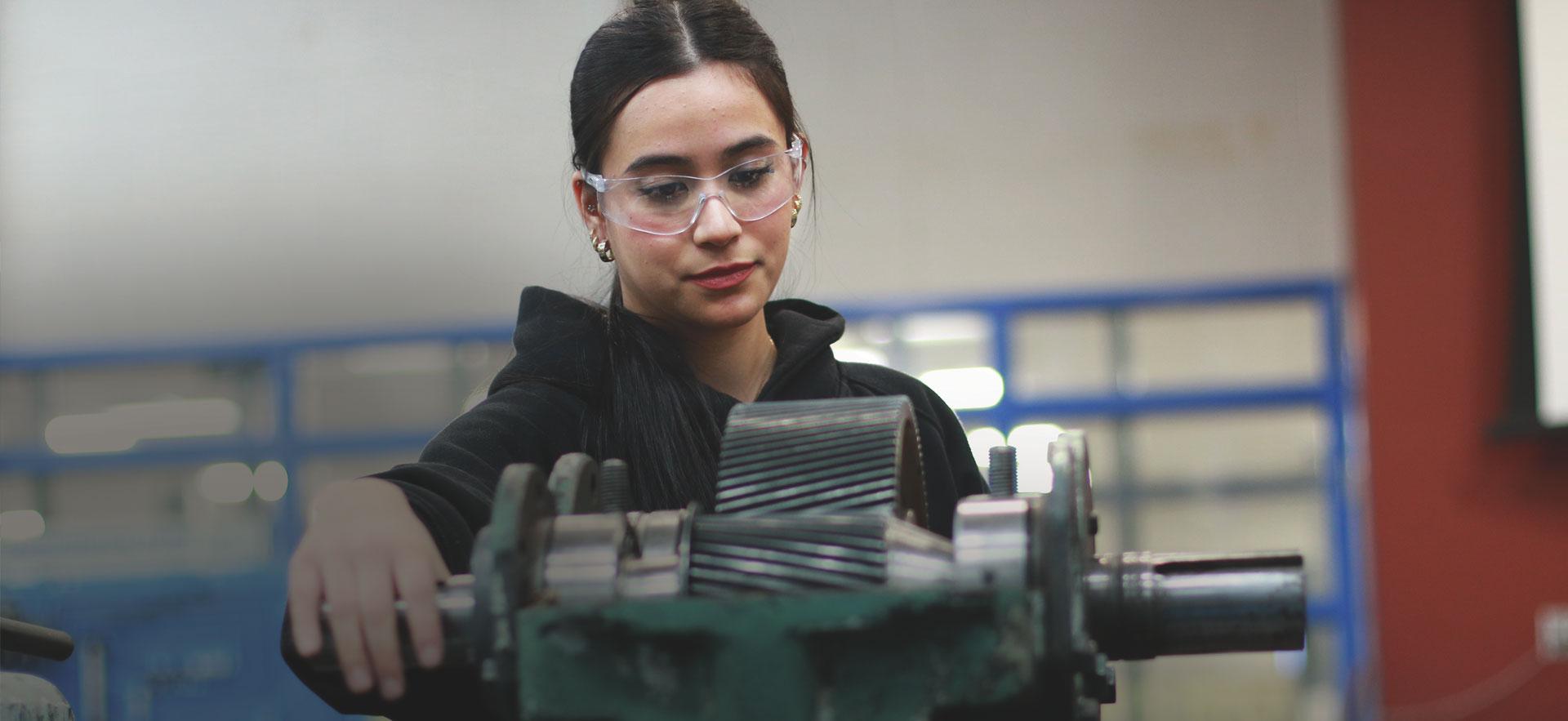Female student at lathe in trades classroom