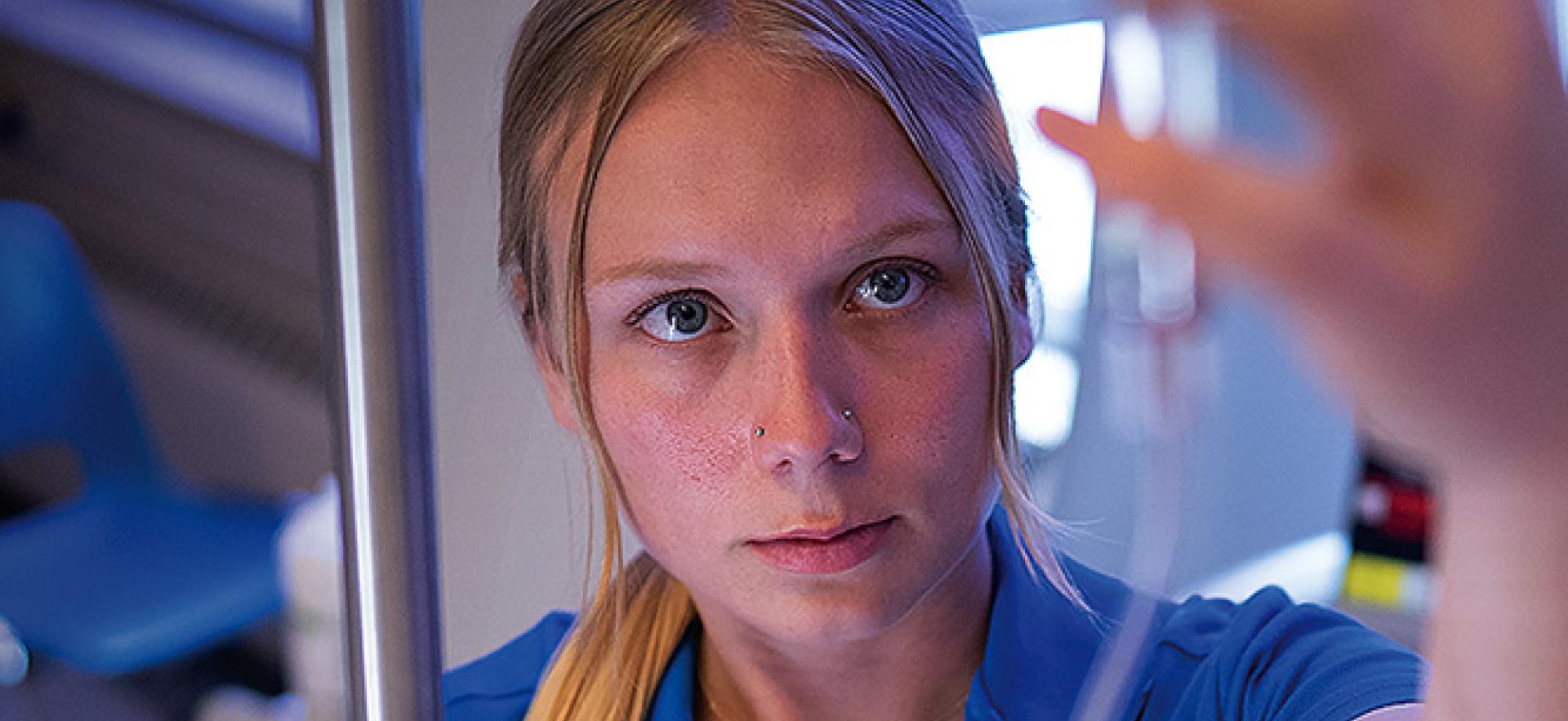 Nursing student checking IV with Think Beyond the Desk text overlay