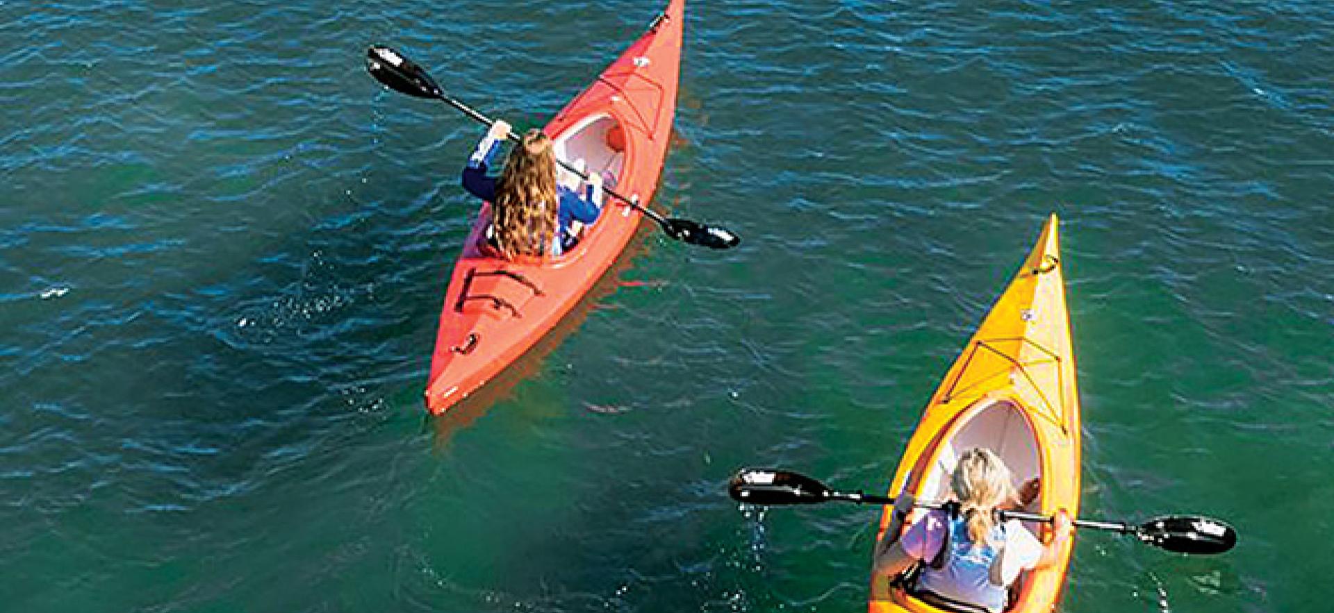 Aerial view of two people kayaking on water with better than pizza days text overlay