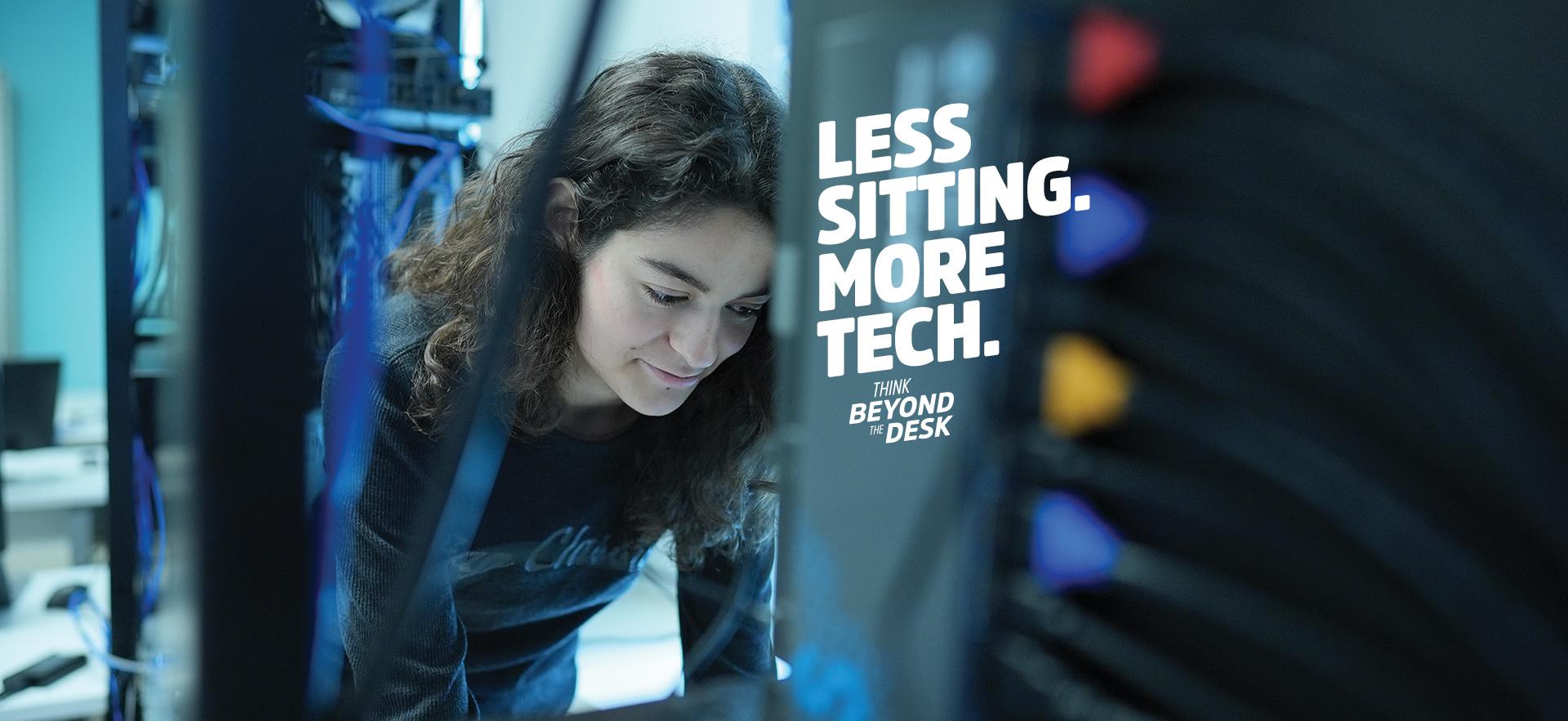 IT student standing and leaning over computer at networking stacks