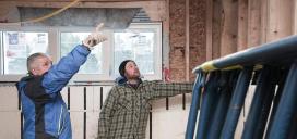 A male Construction Techniques student listens to his instructor at a building site.ç 