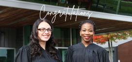 Two students wearing robes for convocation ceremony with congratulations written above in white script font