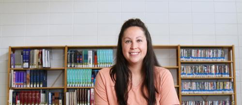 A Community Integration Through Cooperative Education student takes a break to smile in the library.  