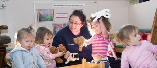 One female Early Childhood Education student plays with young children.