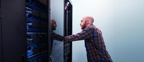 Male computer technician reviews a Sault College computer server.