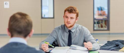 Two male business students discussing a project.