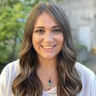 Recruiter Carly smiling looking at the camera standing outside on campus